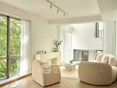 Elegant living room with plush seating and large window offering natural light.