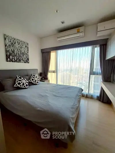 Modern bedroom with large window and stylish decor in high-rise apartment