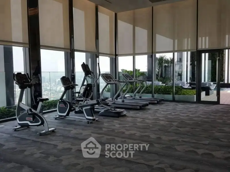 Luxurious high-rise gym with panoramic city views and modern fitness equipment.