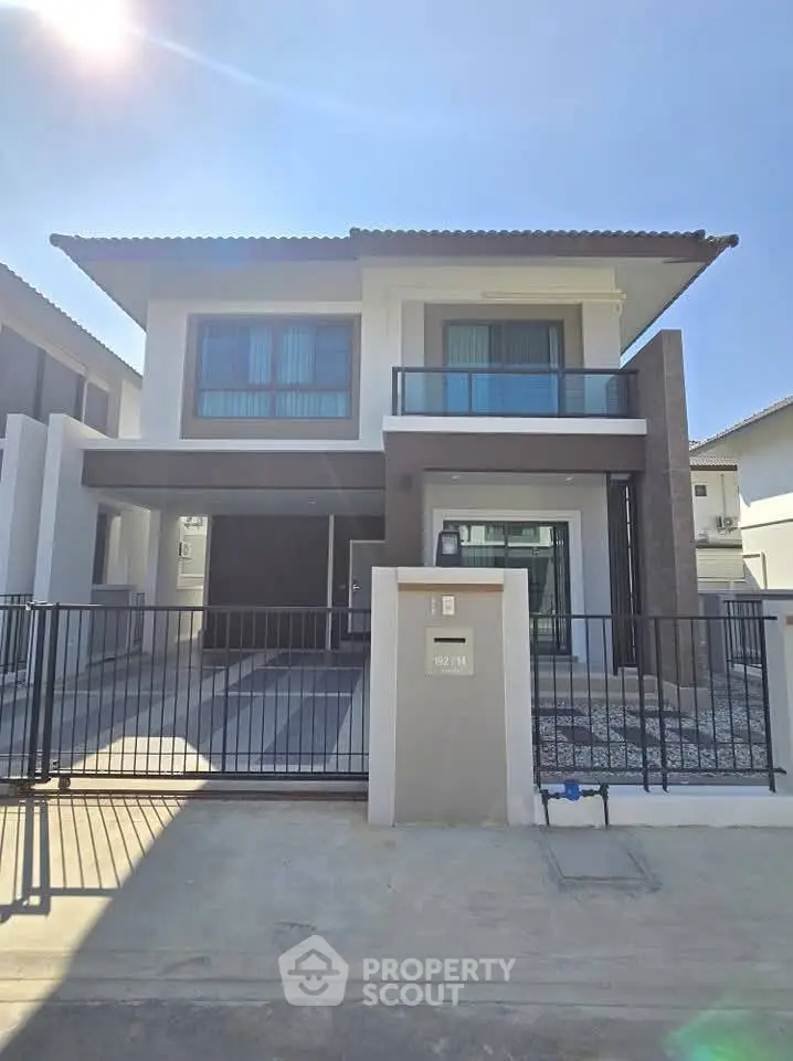 Modern two-story house with sleek design and spacious driveway in a sunny neighborhood.