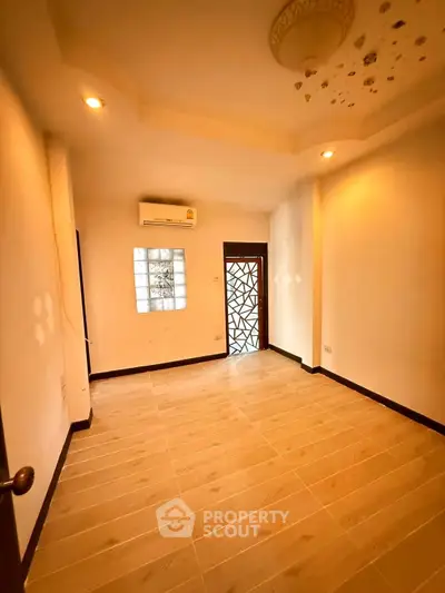 Spacious room with elegant lighting and wooden flooring, perfect for a cozy living space.