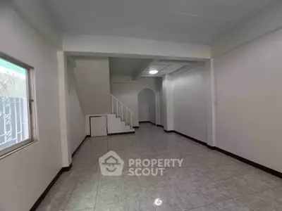 Spacious interior with tiled flooring and staircase, perfect for customization.