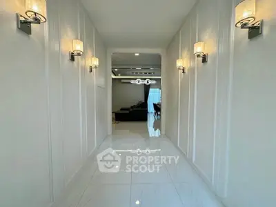 Elegant hallway with modern lighting leading to a spacious living area with a view.