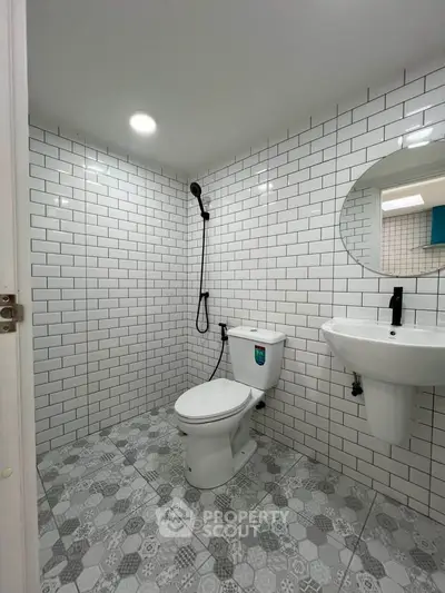 Modern bathroom with white subway tiles and geometric floor design