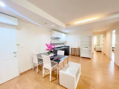 Spacious open-plan living and dining area with modern kitchen in a bright apartment.