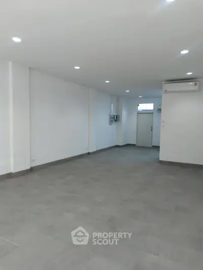 Spacious empty room with modern lighting and air conditioning, perfect for customization.