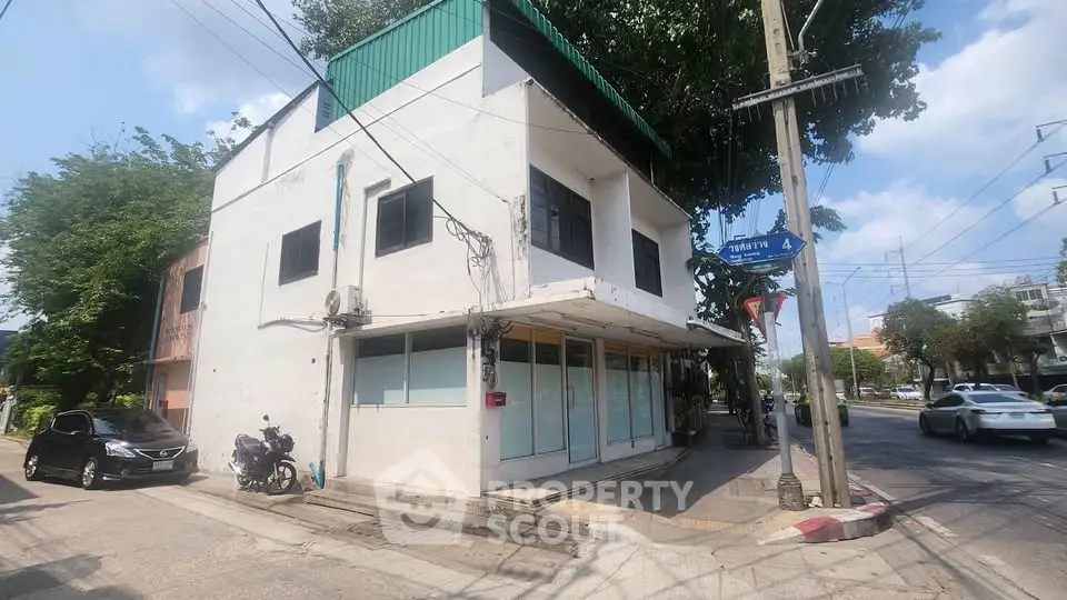 Corner commercial building with large windows on a busy street, ideal for retail or office space.