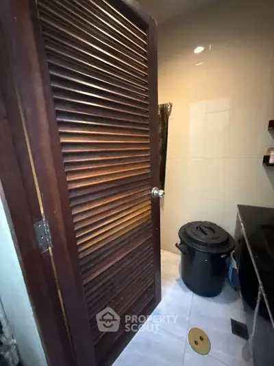 Compact bathroom with wooden door and modern fixtures