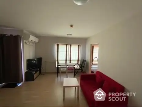 Spacious living room with red sofa and natural light