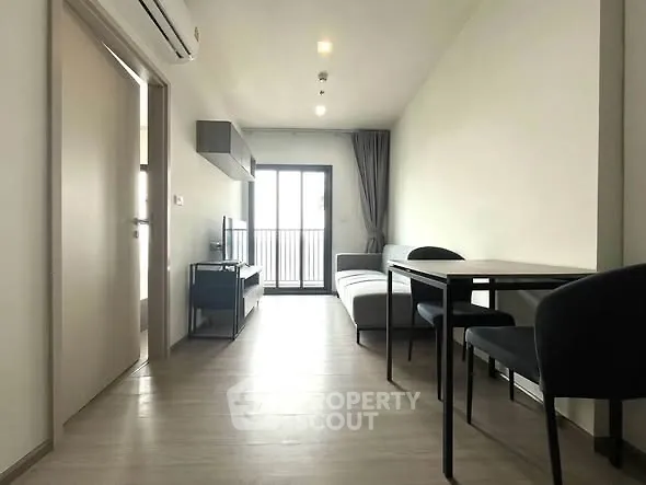 Modern living room with sleek furniture and balcony access in a stylish apartment.