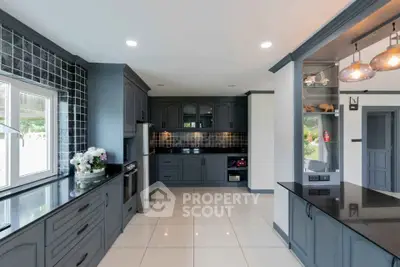 Modern kitchen with sleek cabinetry and black countertops in a spacious layout.