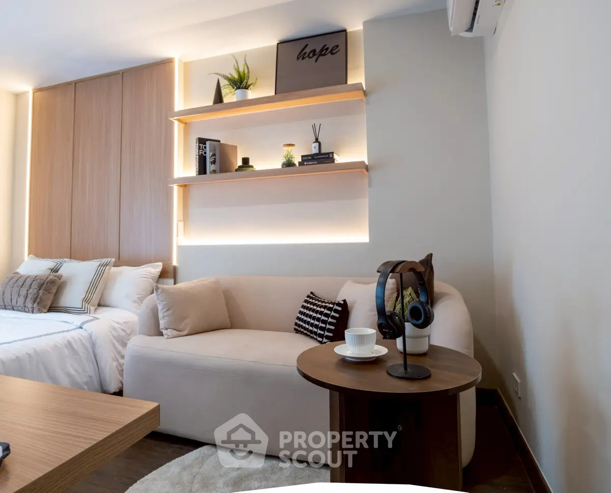 Modern living room with cozy sofa, stylish shelves, and elegant decor in a contemporary apartment.