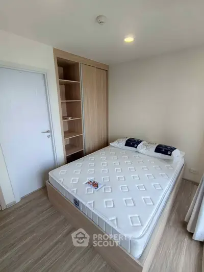 Modern bedroom with built-in wardrobe and comfortable bed in a bright apartment.