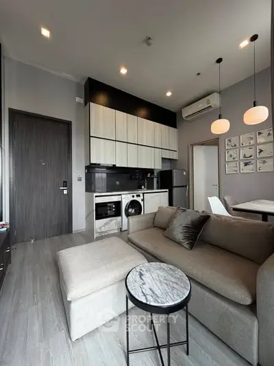 Modern living room with open kitchen, featuring sleek furniture and stylish lighting in a contemporary apartment.