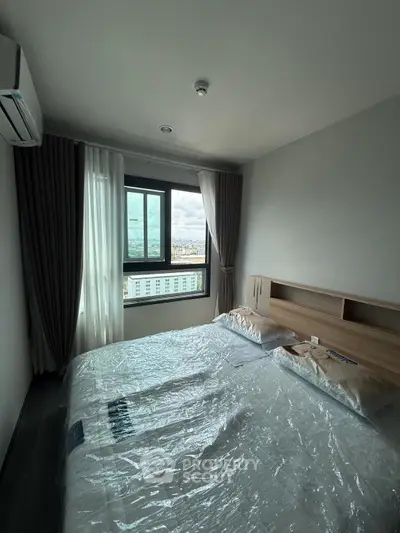 Cozy bedroom with city view, modern furnishings, and ample natural light.