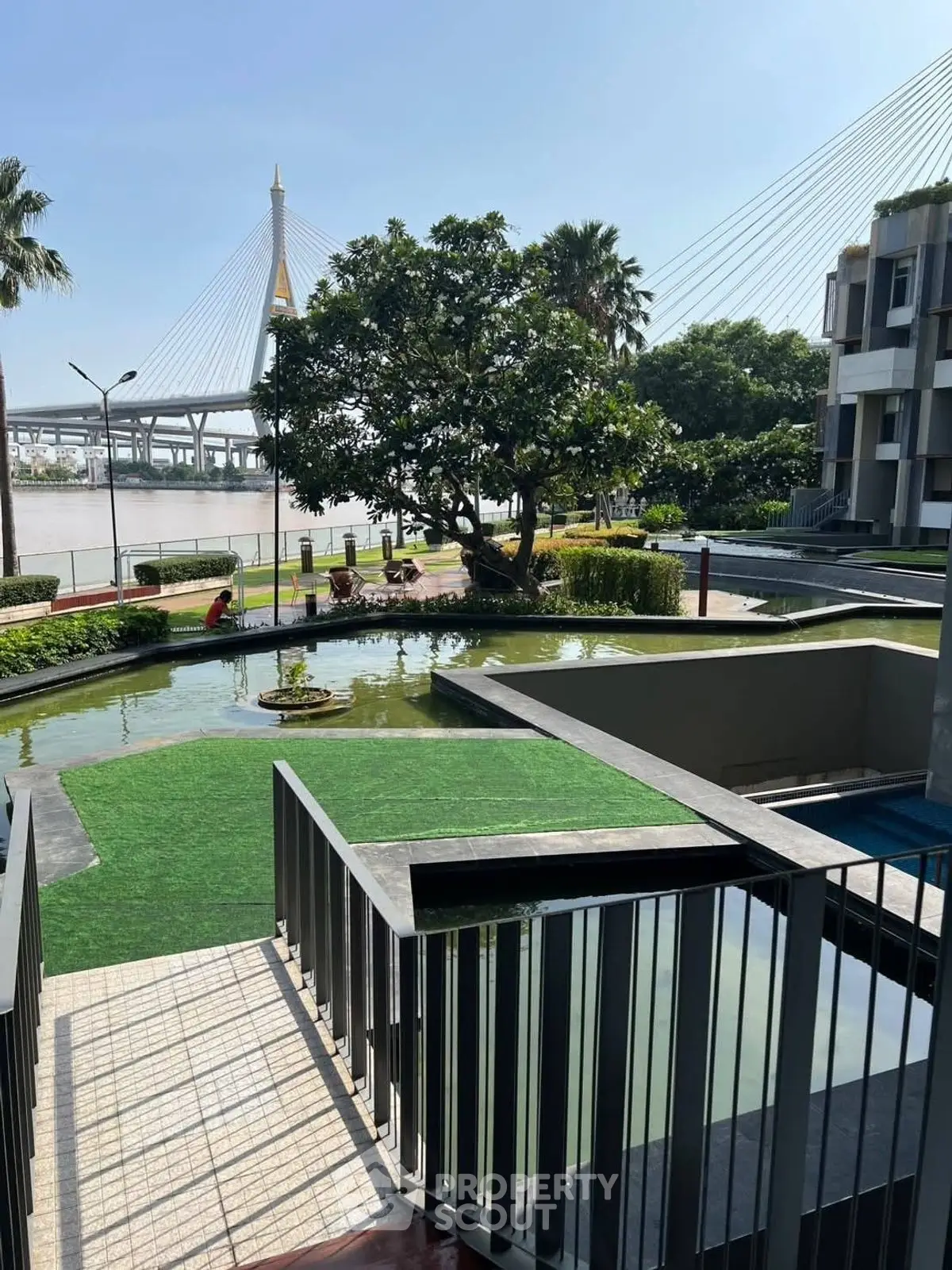 Modern riverside property with lush garden and scenic bridge view