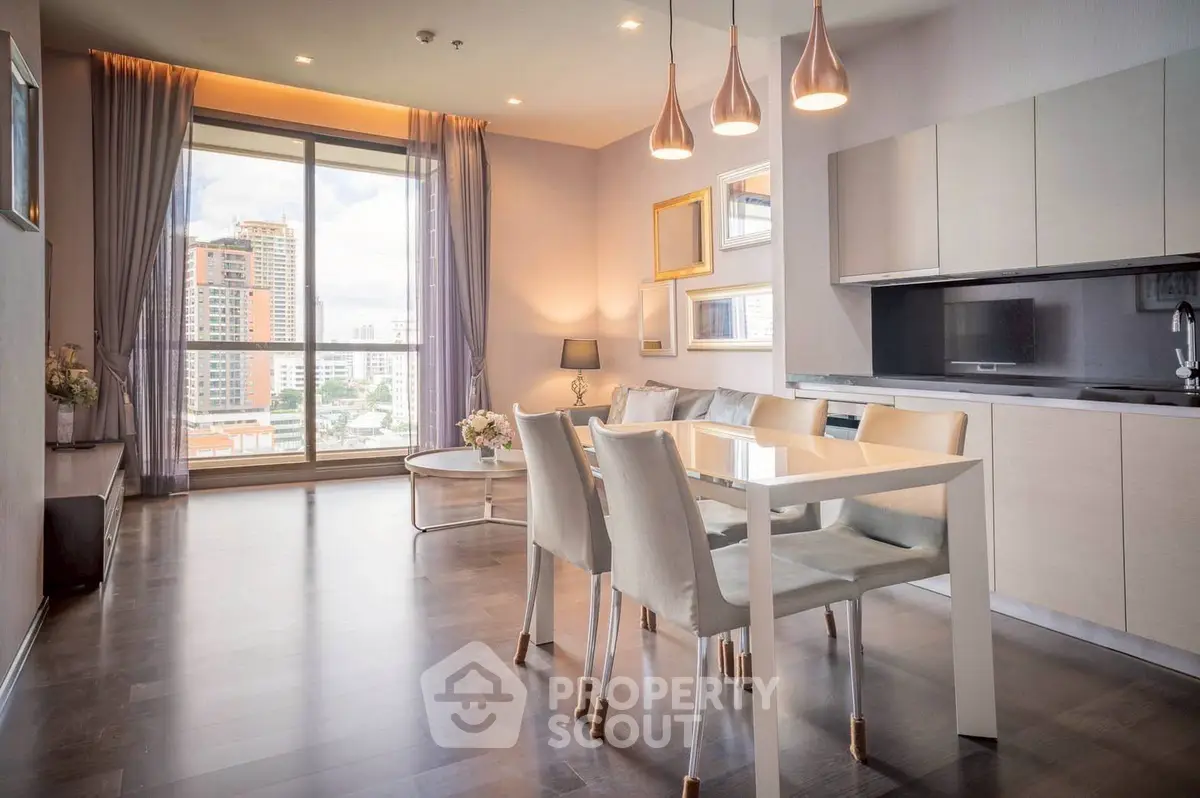 Modern open-plan living room with dining area and large window view in luxury apartment.