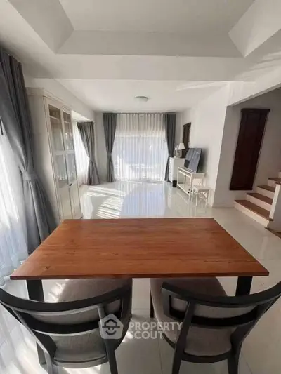 Spacious and bright living room with elegant dining area and large windows.