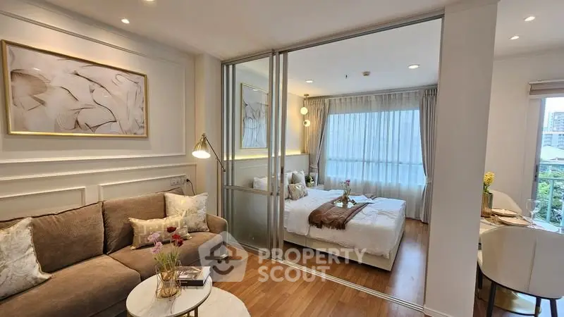 Modern open-plan living room and bedroom with elegant decor and natural light.