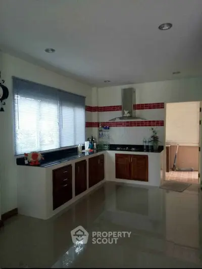 Spacious kitchen with modern cabinetry and large window for natural light.