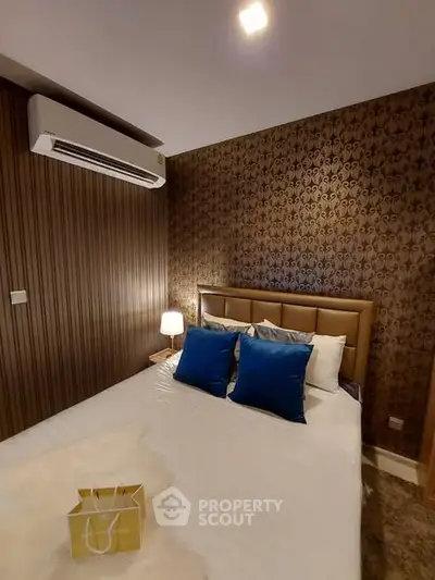 Luxurious bedroom with elegant wallpaper and plush bedding, featuring modern air conditioning for ultimate comfort.