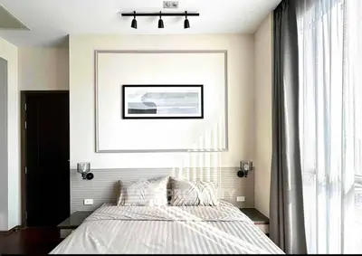Modern bedroom with stylish decor and natural light through large windows.