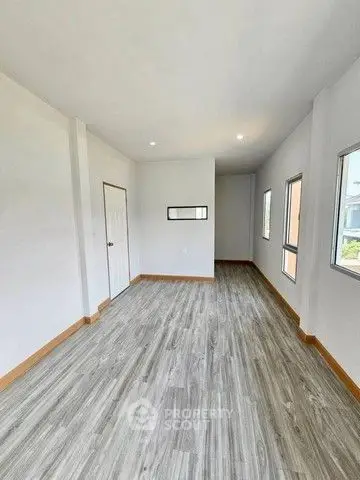 Spacious and bright room with modern flooring and ample natural light.