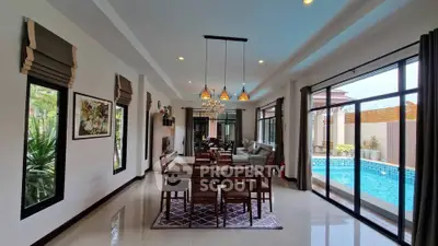 Luxurious open-plan living room with pool view, elegant dining area, and modern decor in a spacious home.
