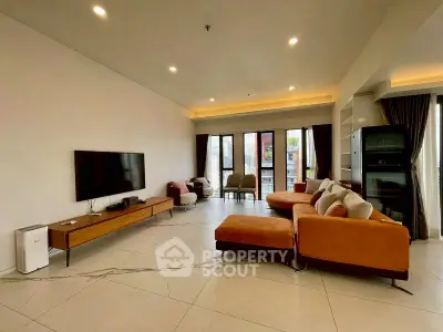 Spacious modern living room with stylish furniture and large windows offering natural light.