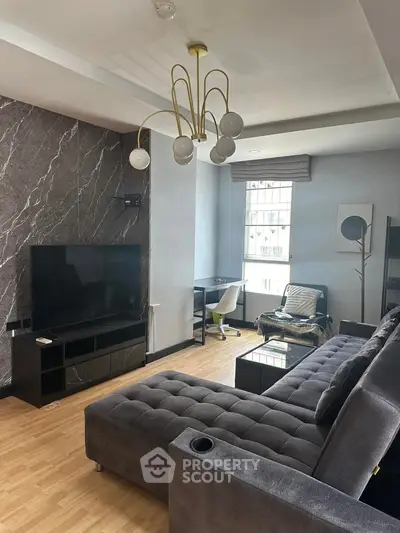 Modern living room with stylish decor and large TV, featuring a cozy sectional sofa and elegant lighting.