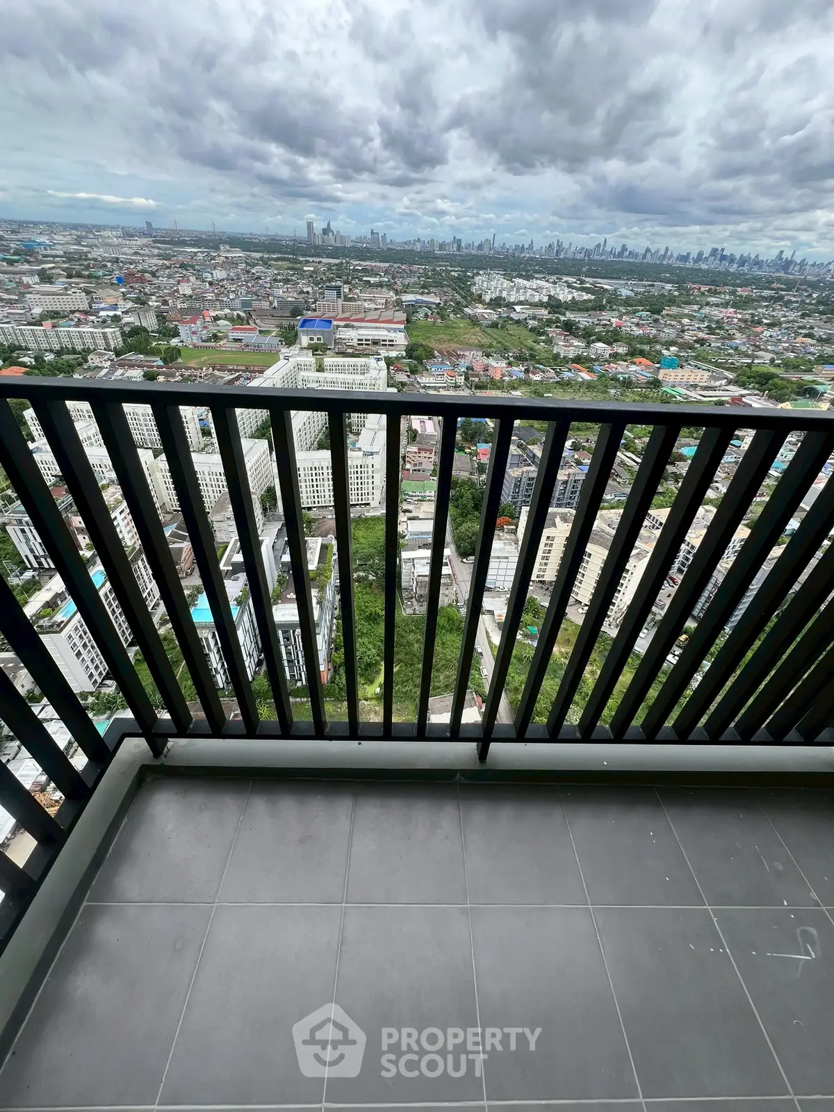 Stunning cityscape view from high-rise balcony with sleek railing design.