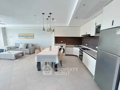 Spacious open-plan living room and kitchen with modern furnishings and ample natural light.
