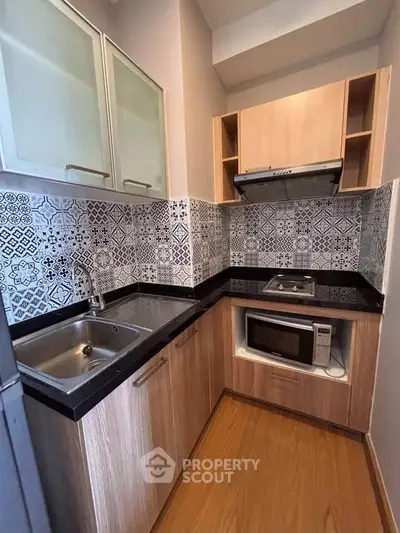 Modern compact kitchen with stylish backsplash and built-in appliances