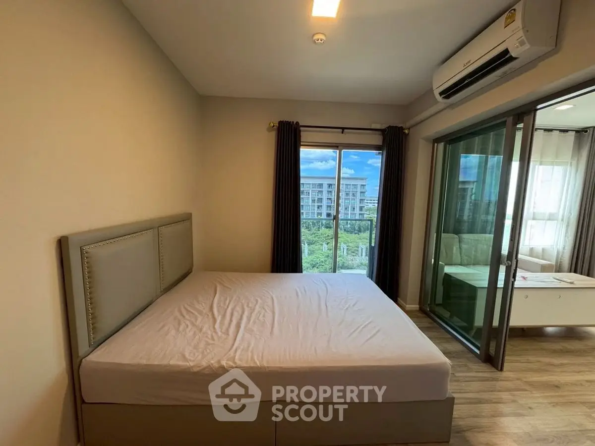 Modern bedroom with large window and balcony view in a stylish apartment.