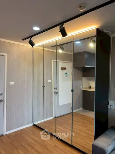Modern apartment interior with mirrored wardrobe and sleek kitchen design