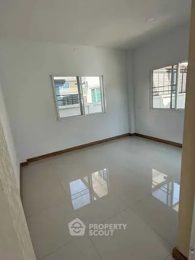 Spacious empty room with large windows and glossy tiled floor, perfect for customization.
