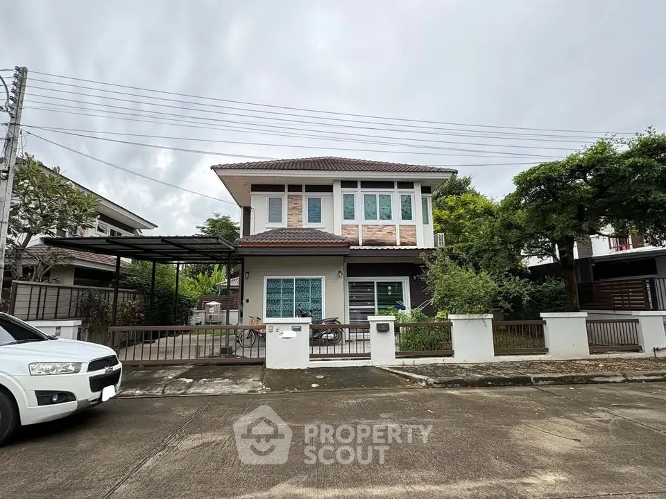 Charming two-story house with modern design and lush greenery in a serene neighborhood.