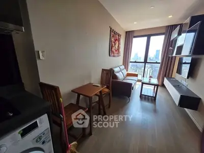 Modern living room with city view, featuring stylish furniture and natural light.