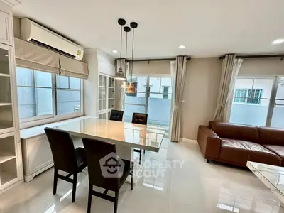 Modern living room with sleek dining area and large windows for natural light