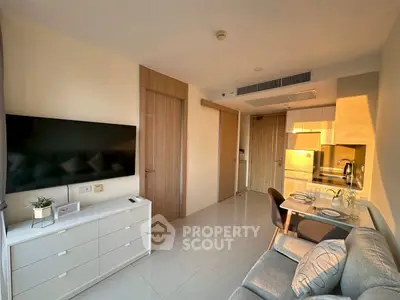 Modern living room with sleek furniture and open kitchen layout, bathed in warm sunlight.