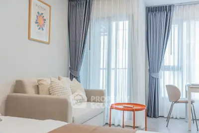 Modern living room with stylish decor and natural light, featuring a cozy sofa and elegant curtains.