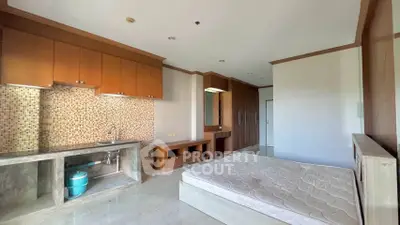 Spacious bedroom with built-in wardrobe and kitchenette in modern apartment