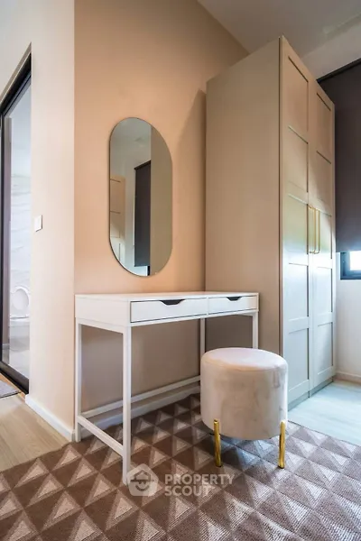 Stylish bedroom corner with modern vanity and plush stool in elegant apartment.