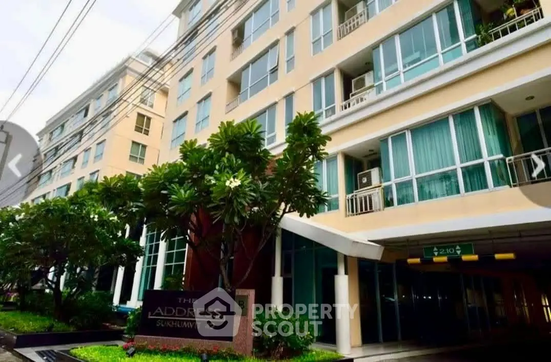 Modern condominium building with lush greenery and spacious balconies in prime urban location.