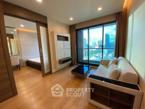 Modern living room with city view, featuring sleek furniture and large windows for natural light.