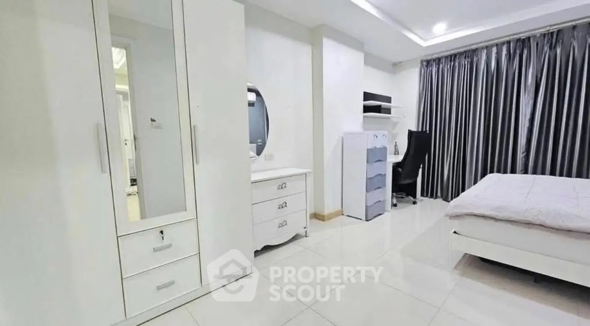 Spacious modern bedroom with sleek white furniture and elegant decor