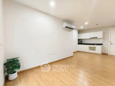 Spacious modern living room with open kitchen and wooden flooring