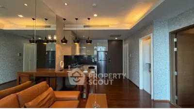 Modern open-layout living room with stylish kitchen and elegant lighting in a contemporary apartment.