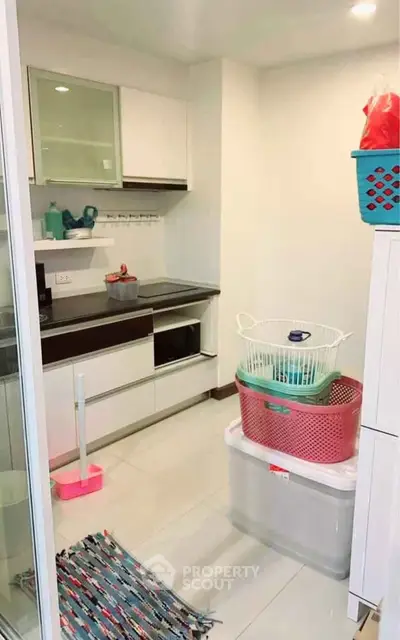 Compact kitchen with modern appliances and storage solutions in a cozy apartment.