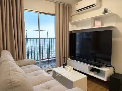 Modern living room with large TV and balcony view